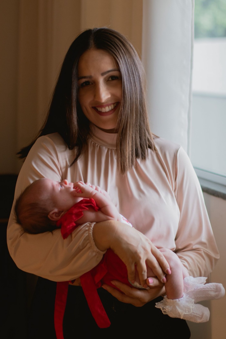 Yeni doğan bebeğini kucağında tutan, gülümseyen bir anne